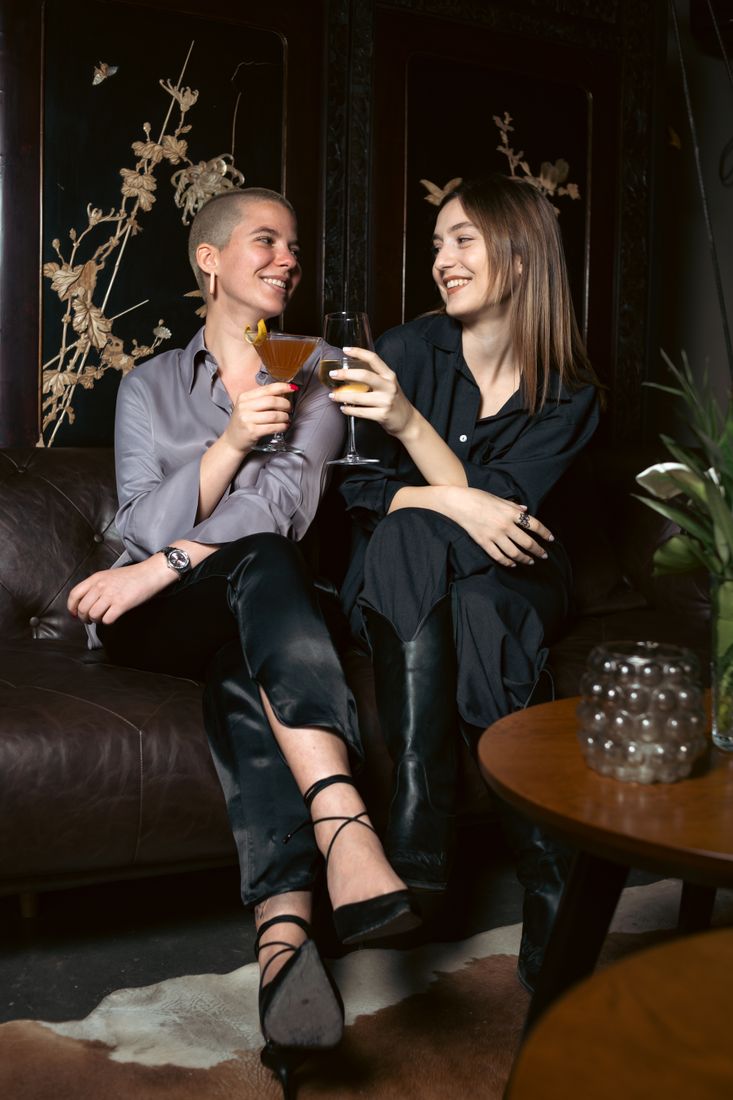 Freundinnen mit Drinks auf dem Lounge-Sofa